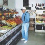 elderly man buys buying produce at grocers