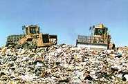 photo of two tractors on a huge heap of trash